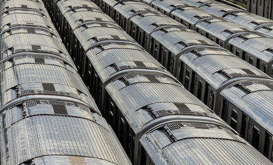Fototapeta premium large group of 7 trains on tracks in train yard (corona flushing meadows queens new york city) transport commute transportation sunshine roofs cars car roof pattern lines abstract nyc commuter line