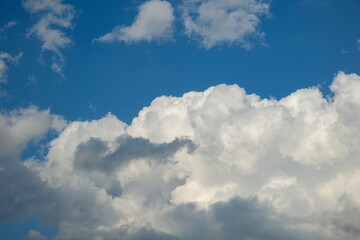 Dramatic puffy white clouds in the blue sky, summed day, no people.