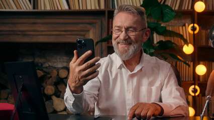 Confident successful old Caucasian man male mature takes off glasses looking at camera folded hands...