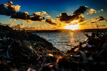 A landscape of a Corsican sunset with clouds and a colorful sky, creating a mystical and...