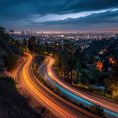 Naklejka premium A winding road with light trails winds through a hillside overlooking a sprawling cityscape at dusk, showcasing urban vibrancy and natural surroundings.