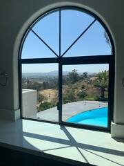 Arched Window Overlooking Pool and Hillside