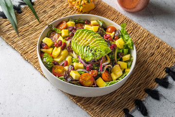 Fresh tropical salad with mango, avocado, and cherry tomatoes in a bowl
