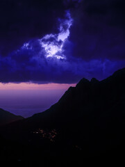 Fototapeta premium A landscape of a Corsican sunset with clouds and a colorful sky, creating a mystical and captivating atmosphere. The contrasts between moonlight and cloud shadows add a dramatic touch. 
