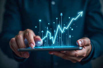 Businessman holding tablet with stock finance candlestick bar chart graph blue glowing floating