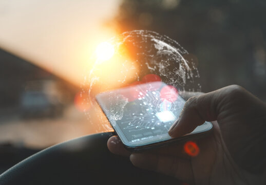 Hand using smartphone with AI interface in a car, digital globe overlay, symbolizing smart mobility and global connectivity.