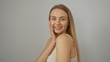 Fototapeta premium Woman smiling confidently against a simple white background, showcasing a bright and positive expression, emphasizing beauty and happiness.