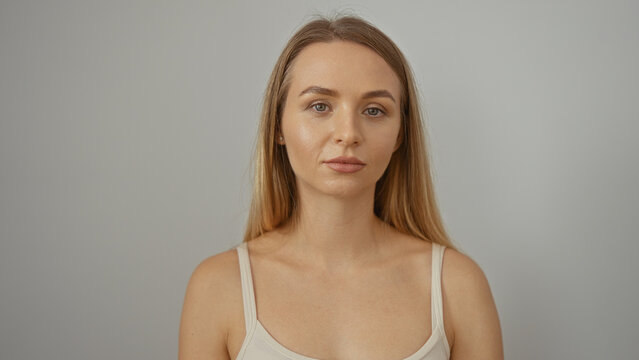 Woman posing isolated on a white background with blonde hair and neutral expression, showcasing beauty and elegance in a simple, calm studio setting.