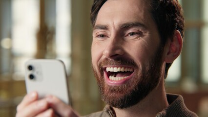 Caucasian funny excited happy man guy businessman laughing video mobile phone gadget laughter fun...