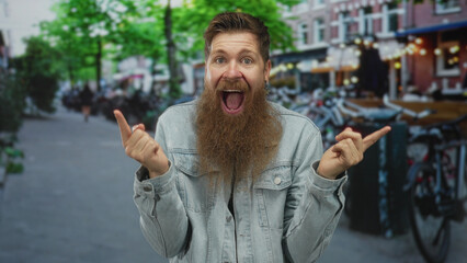 Man with long reddish beard pointing finger to both sides in busy city street lined with parked...