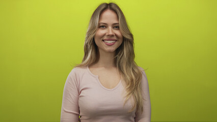 Obraz premium Woman with long blonde hair smiles showing face toward camera in studio portrait; cheerfulness confidence.