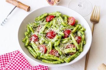 Pasta casarecce with pesto sauce, tomatoes and cheese. Italian cuisine. Vegetarian food.