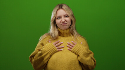 Woman in yellow sweater making expressions against a solid green background showing various moods in a minimalist setup