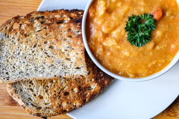 A Bowl Of Hot Nourishing Vegetarian Lentil Soup Garnished With Parsley Served With Toast