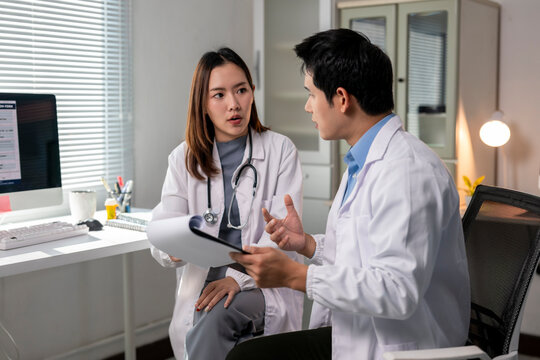 A doctor and a nurse are talking in a hospital room - Powered by Adobe