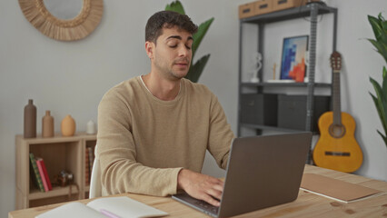 Man opens laptop and starts typing at home, computer activities attract guy young hispanic to desk...