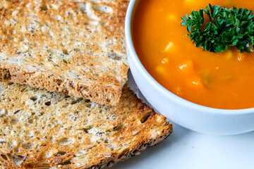 A Bowl Of Healthy Vegetable Soup Garnished With Parsley And Served With Toasted Bread