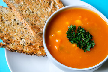 A Bowl Of Healthy Vegetable Soup Garnished With Parsley And Served With Toasted Bread