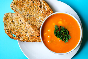 A Bowl Of Healthy Vegetable Soup Garnished With Parsley And Served With Toasted Bread