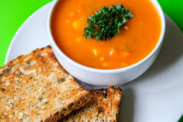 A Bowl Of Healthy Vegetable Soup Garnished With Parsley And Served With Toasted Bread