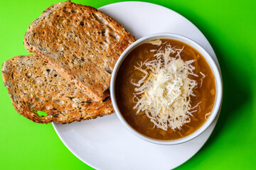 A Bowl Of Traditional French Onion Soup Topped With Grated Cheese And Toasted Bread