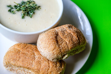 Bowl Of Chicken Soup With Thyme Garnish And Wholemeal Submarime Bread Rolls