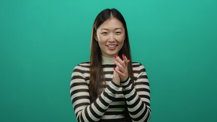Obraz premium Woman smiling in striped shirt against a vibrant green background showcasing happiness and positivity.