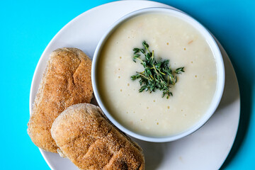 Bowl Of Chicken Soup With Thyme Garnish And Wholemeal Submarime Bread Rolls