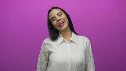 Fototapeta premium Woman smiling playfully sticking tongue out against vibrant pink background exuding cheerful and fun personality in a vibrant setting for youth and positivity themed content