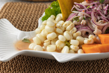 Peruvian ceviche with choclo, sweet potato, red onion, and plantain chips served on fish-shaped plate