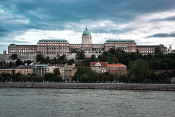 Buda Castle and colorful riverside buildings viewed from across the Danube River in Budapest, Hungary
