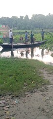 Serene River Crossing: Men Transporting Bicycles on a Traditional Boat in Rural Bangladesh.