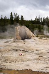 an old dilapidated geyser crater from which steam escapes