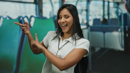 Young woman gesturing and smiling inside a bus, showcasing vibrant movement and expression in a...
