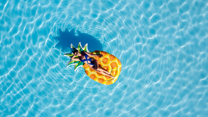 Young beautiful woman relaxing in a pool on a sunny summer day. Concept summer vibes, relaxation,...