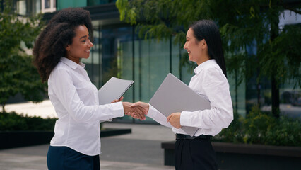 African American Asian Korean women handshaking meet greeting businesswomen business colleagues...