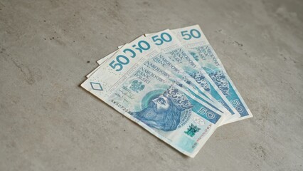 Polish 50 zloty banknotes on a grey concrete surface representing finance, currency, and economy in...