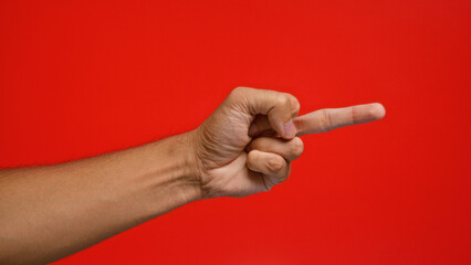 Man showing a hand making an insulting gesture against a vibrant red background, emphasizing a rude...
