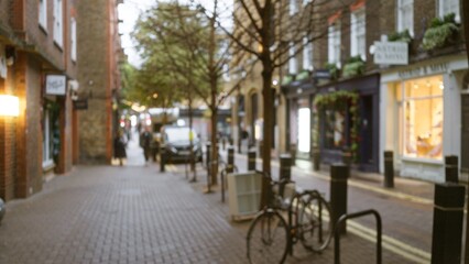 Fototapeta premium Blurry view of a london street in seven dials during winter, with out-of-focus pedestrians and bicycles, showcasing the urban essence of an english cityscape.