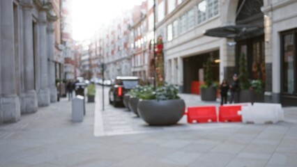 Defocused winter street scene in london with blurred pedestrians and cars, featuring urban...