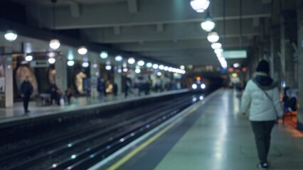 Man walking on blurred london subway platform with bokeh lights showcasing defocused urban commute...