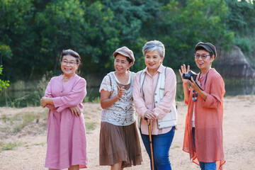 Senior Asian women standing smiling relaxing outdoor nature cheerful casual clothing enjoying...