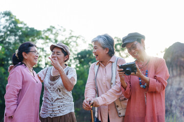 Senior Asian women laughing cheerful viewing camera photos outdoor nature casual clothing vacation adventure travel lifestyle freedom relaxing refreshing friendship bonding leisure happiness journey