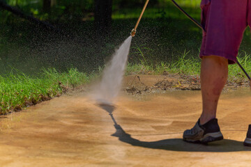 Cleaning concrete in the garden with a pressure washer