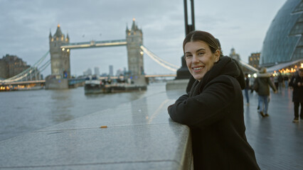Woman smiling on a london bridge with tower bridge in the background, showcasing urban landscape...