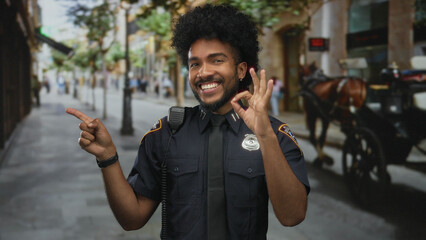 Smiling policeman making an okay gesture on a city street, capturing a moment of friendly urban...