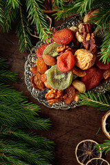 Assorted dried fruits and nuts on a silver tray.