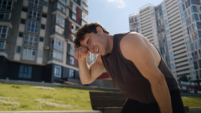 Tired Caucasian European young man sportsman running jogging morning training workout cardio exhausted guy male hard breathing stopping rest relaxing pause city outdoor sport healthy lifestyle runner - Powered by Adobe