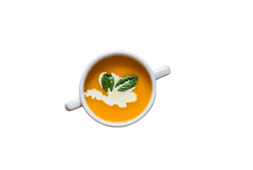 A white ceramic bowl of creamy pumpkin soup, garnished with cream and fresh spinach leaves. Top...
