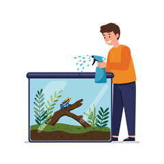 Caring for an exotic pet at home: spraying water from a spray bottle on a poison dart frog terrarium with green plants and driftwood.